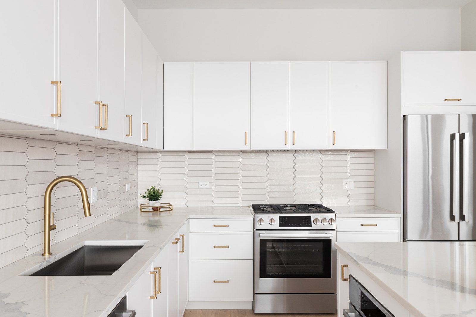 Kitchen with white cabinetry and gold fixtures