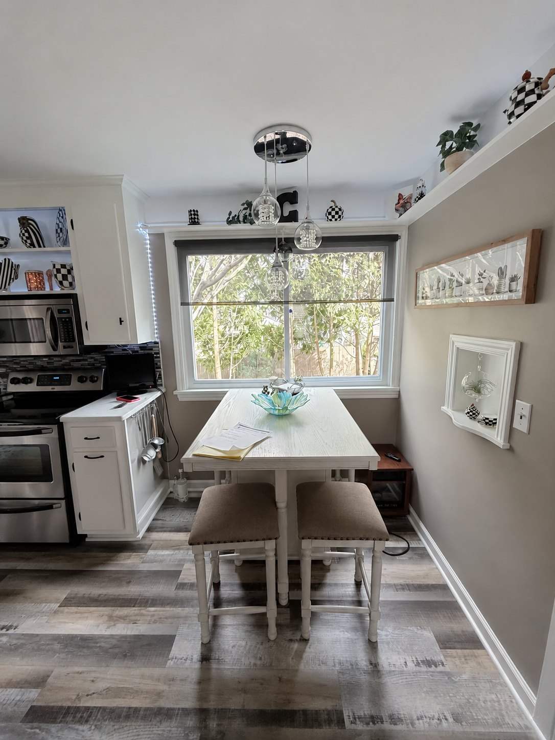 Dining nook with a bay window, pendant lights and vinyl plank flooring