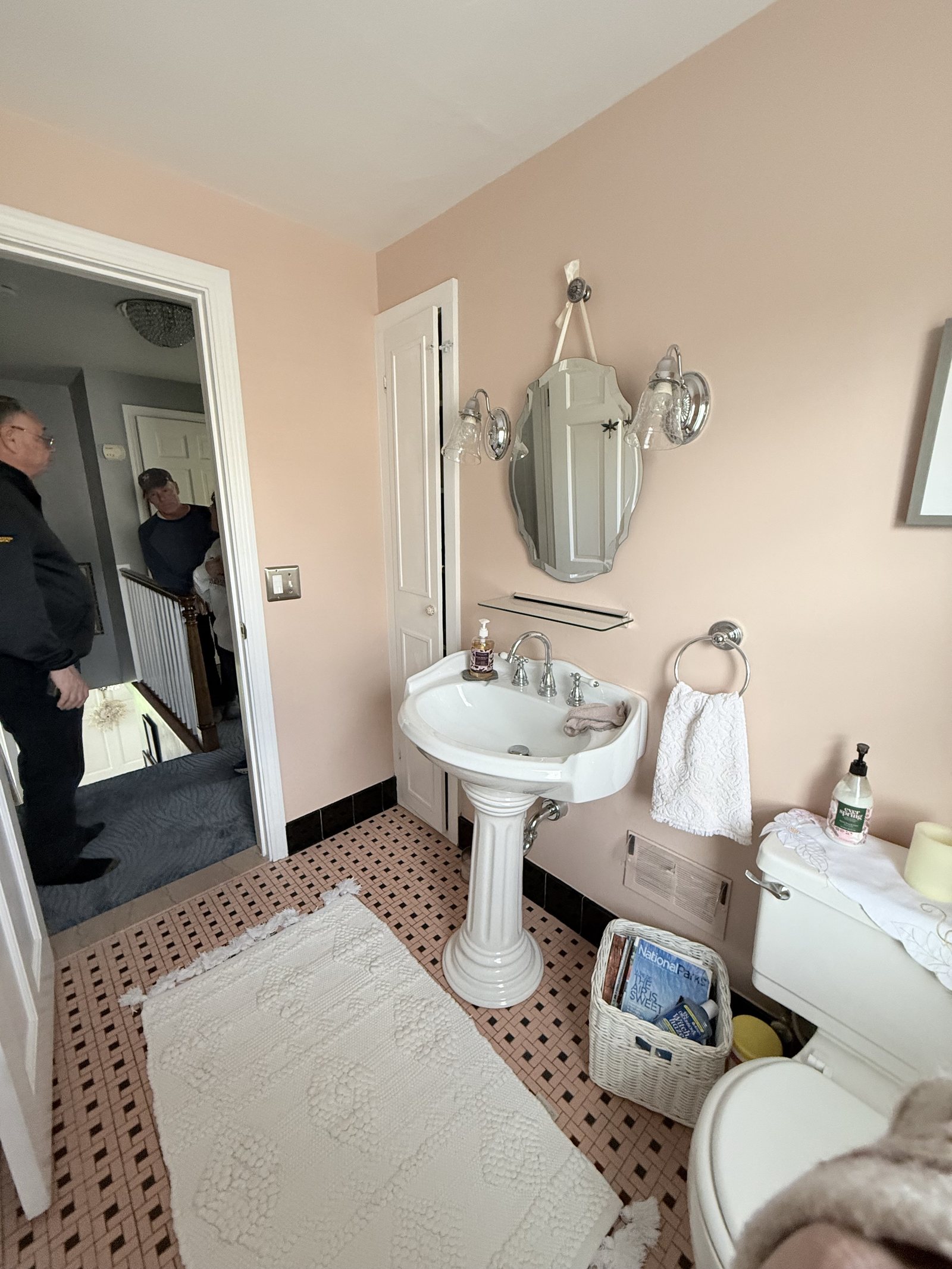 Peach basketweave tile and a dated pedestal sink — before Dreamspace renovated it