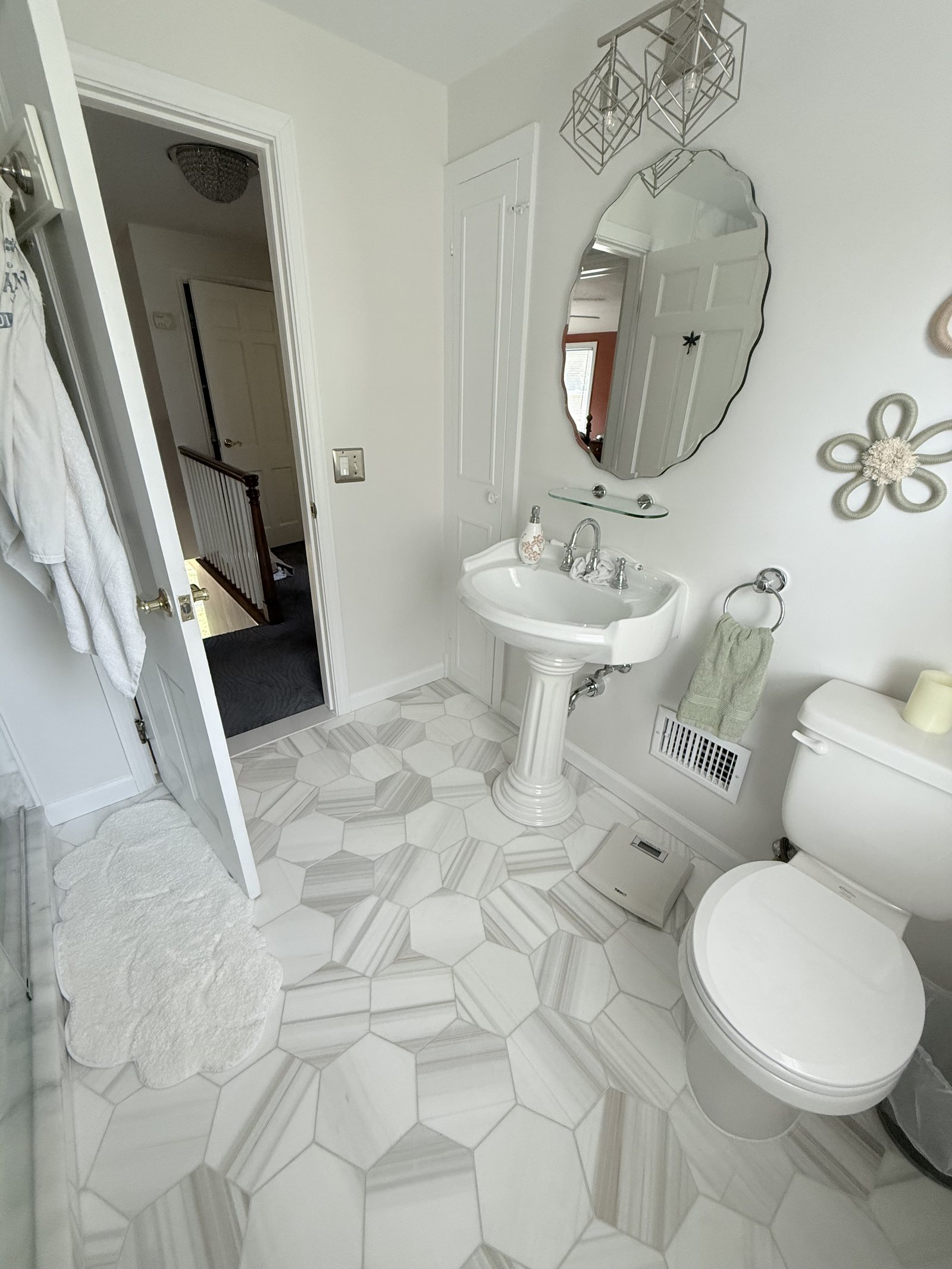 Bathroom with marbled hexagon floor tile and a pedestal basin